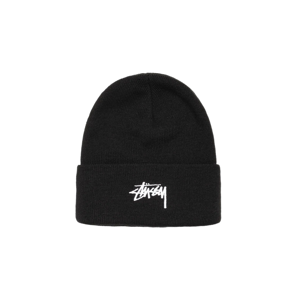 A black knit beanie hat with a white embroidered Stüssy logo on the front cuff, photographed against a clean white background.