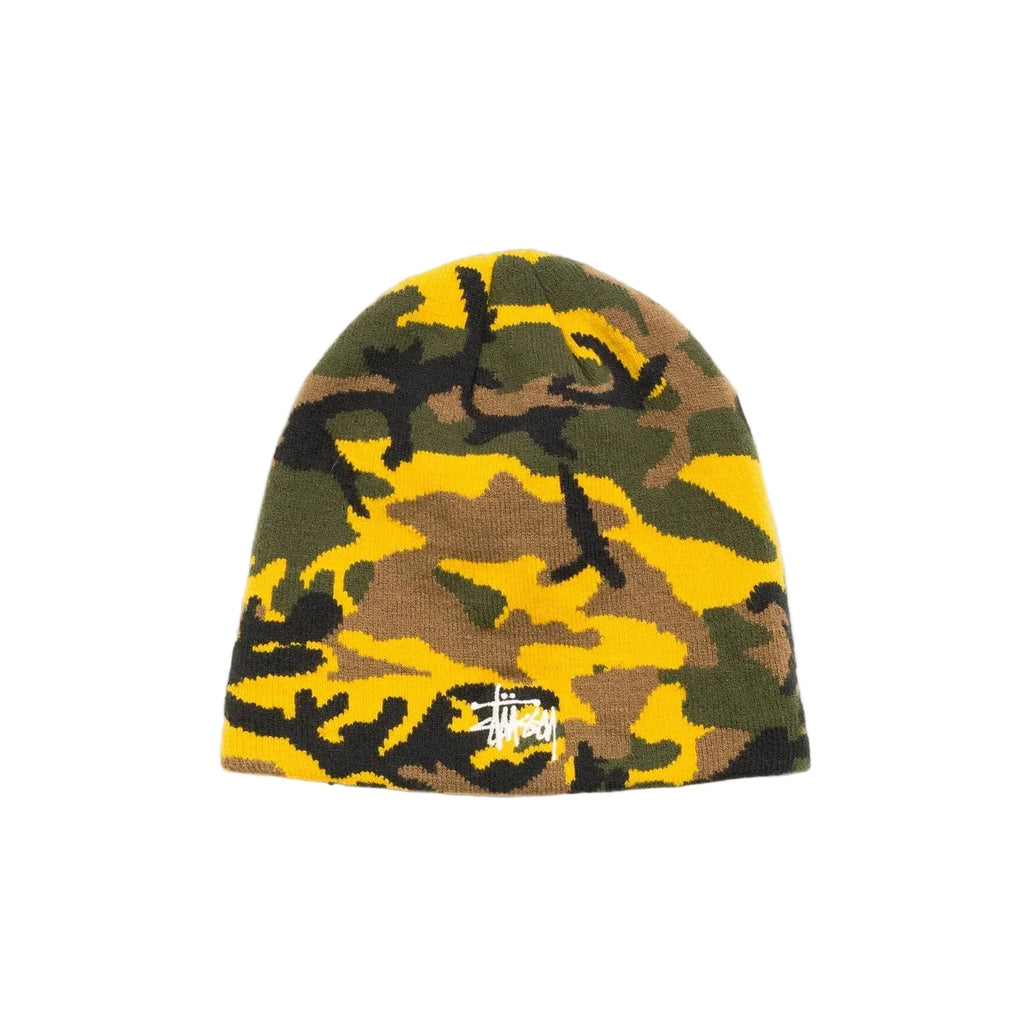A Stussy beanie hat featuring a yellow, green, and brown camouflage pattern with a small white embroidered Stussy logo on the front, set against a plain off-white background.